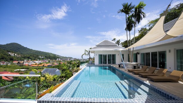 A rooftop infinity pool with a clear view of the surrounding landscape, including palm trees and distant buildings. - Luxury Matahari Seaview (Kamala)
