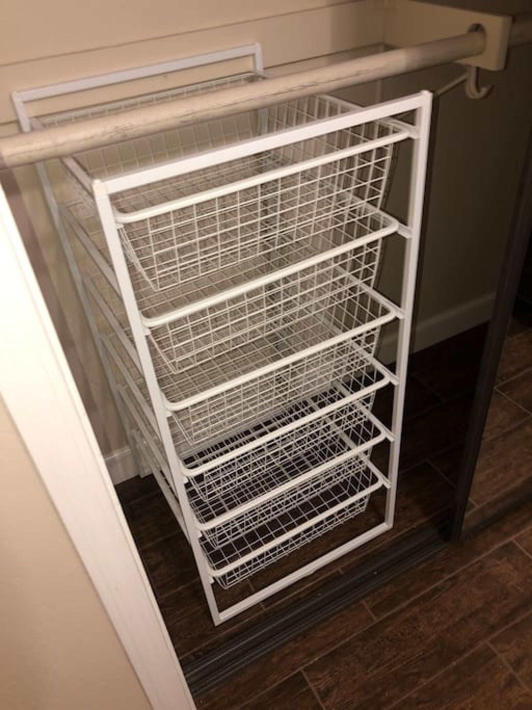 A white metal shelving unit with multiple compartments, likely used for storage in a kitchen or utility area.