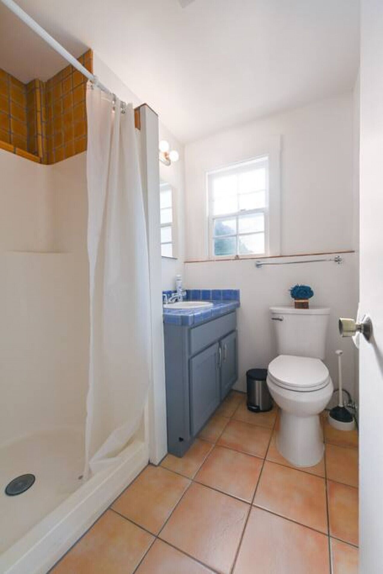 A compact bathroom with a shower, toilet, and sink.