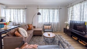 A modern living room with a sofa, armchair, coffee table, and TV. - 117 Wainaku St, Hilo, Unit C (Hilo)