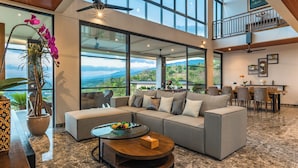 A spacious living area with a large sofa, a coffee table, and a view of the outdoors. - Villa Lovina Hill Paradise (Banjar)