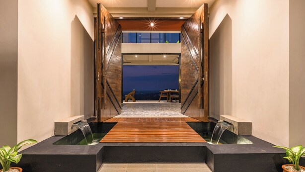 A modern interior with a wooden floor leading to a seating area with a view of the night sky. - Villa Lovina Hill Paradise (Banjar)