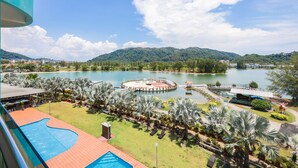 Un complexe hôtelier doté d’une piscine, d’un bassin circulaire et offrant une vue sur un lac et des montagnes.