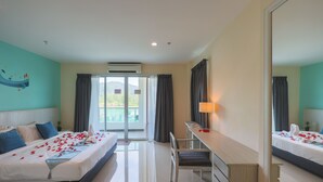 A hotel room with a bed, a desk, a chair, and a large window.
