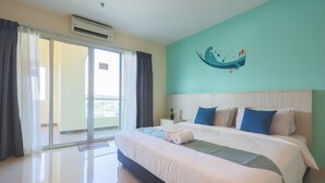 Une chambre d’hôtel avec un grand lit, une vue sur la ville depuis le balcon et un mur de couleur turquoise orné d’une fresque.