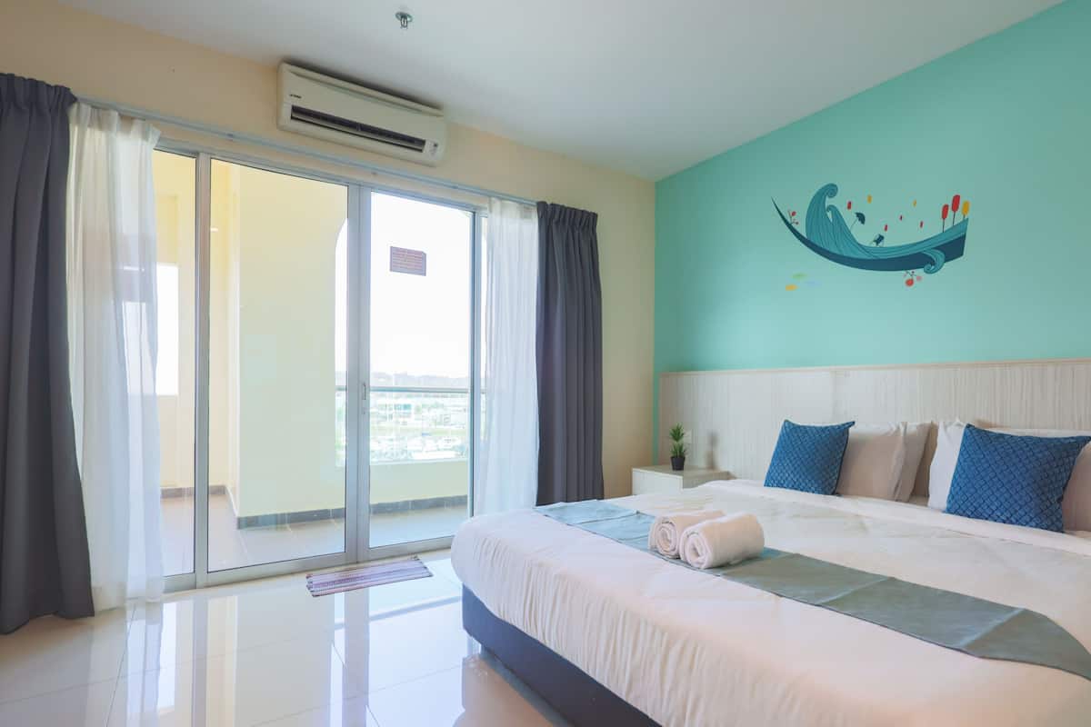 Een hotelkamer met een groot bed, uitzicht op de stad via het balkon en een wand in teal met een muurschildering.