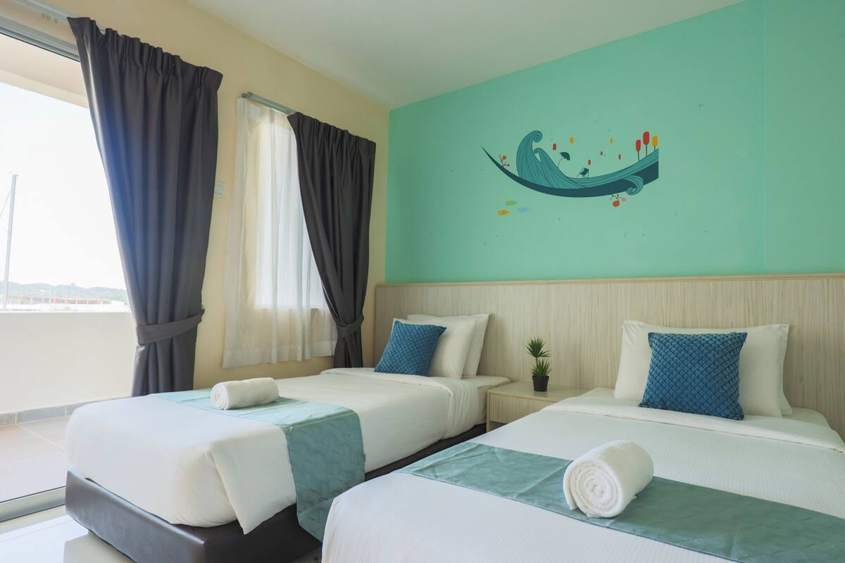 Een hotelkamer met twee bedden, uitzicht op zee en een muurschildering.