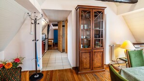 Una habitación con un armario de madera, un perchero y una silla.