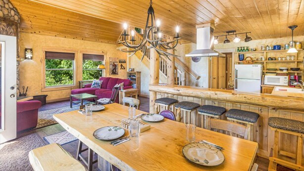Un interior de madera con comedor, cocina y sala de estar.