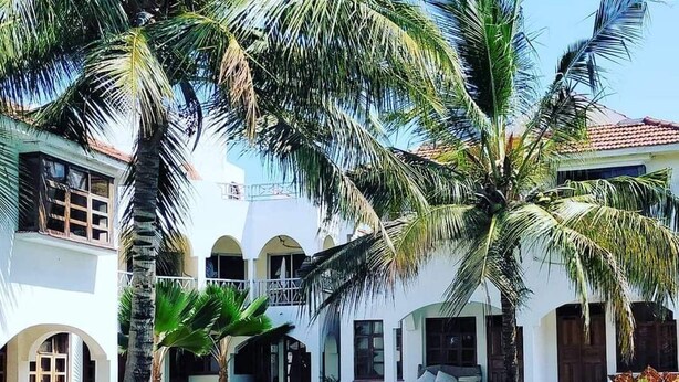A poolside area with lounge chairs and palm trees. - Charming two bedroom villa with WiFi, AC in fantastic Diani (Diani)