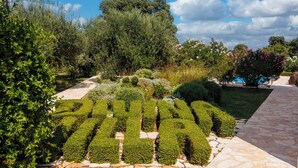 A garden with neatly trimmed hedges spelling out "PALACE" and a stone pathway. - Pool Villa Divina (Liznjan)
