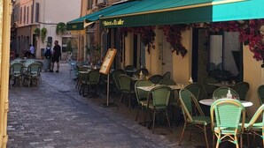 A narrow street with outdoor seating at a restaurant. - Le Meynadier dans le centre historique (Cannes)