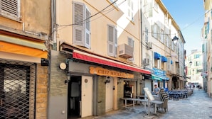 A narrow street with a restaurant named "Chez Mikhail" and a café named "La Creperie." - Le Meynadier dans le centre historique (Cannes)