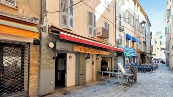 Une rue étroite où se trouvent un restaurant appelé « Chez Mikhail » et un café appelé « La Crêperie ».