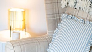 A cozy corner with a plaid sofa, striped pillows, and a lamp. - Heatherwood Cottage - Central Scone (Scone)