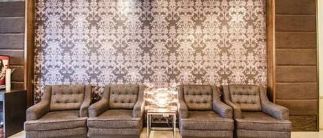 A living room with a patterned wallpaper, two sofas, and a small coffee table.