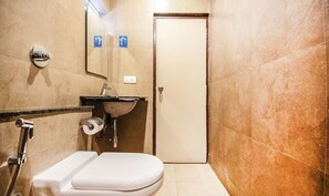 Un baño pequeño con inodoro, lavamanos y ducha.
