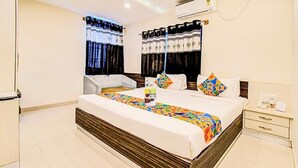 Habitación de hotel con una cama grande, una mesita de noche, una silla y una ventana con cortinas.