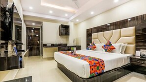 A modern hotel room with a large bed, a small desk, and a bathroom. - Fabhotel Khb Tower (Bengaluru)
