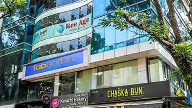 A modern building with a glass facade, featuring signs for 'Ree Age' and 'Tab Hotels'. - Fabhotel Khb Tower (Bengaluru)