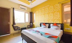 A hotel room with a bed, a desk, a chair, and a window. - Fabexpress Bzoy Inn (Dehradun)