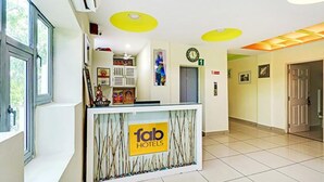 A hotel reception area with a 'fab hotels' sign, a clock, and a door marked '1'.