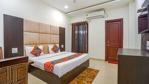 Une chambre d’hôtel équipée d’un lit, d’un bureau, d’une armoire et d’un appareil de climatisation.