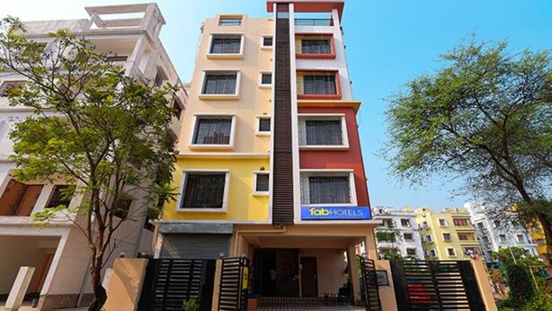 Un hôtel à plusieurs étages doté d’une façade moderne, sur laquelle on peut voir une enseigne bien visible indiquant « Fab Hotels ». L’immeuble a un toit plat et de nombreux balcons.