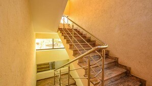 Una escalera de piedra con barandilla de metal que lleva a un piso superior.