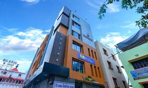 A multi-story building with a sign for 'Fab Hotels' and another sign for 'Y Hotel'. - Fabhotel 9Th Street (Bhubaneshwar)