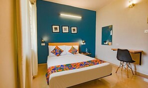 Una habitación de hotel con una cama, un escritorio y una silla.