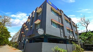 Un hotel de varios pisos con diseño moderno, que cuenta con balcones y un cartel llamativo.