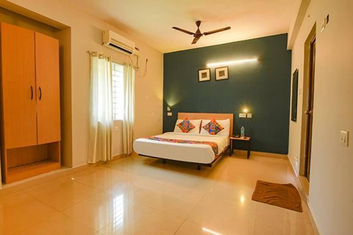 A bedroom with a bed, a ceiling fan, a nightstand, and a wardrobe.