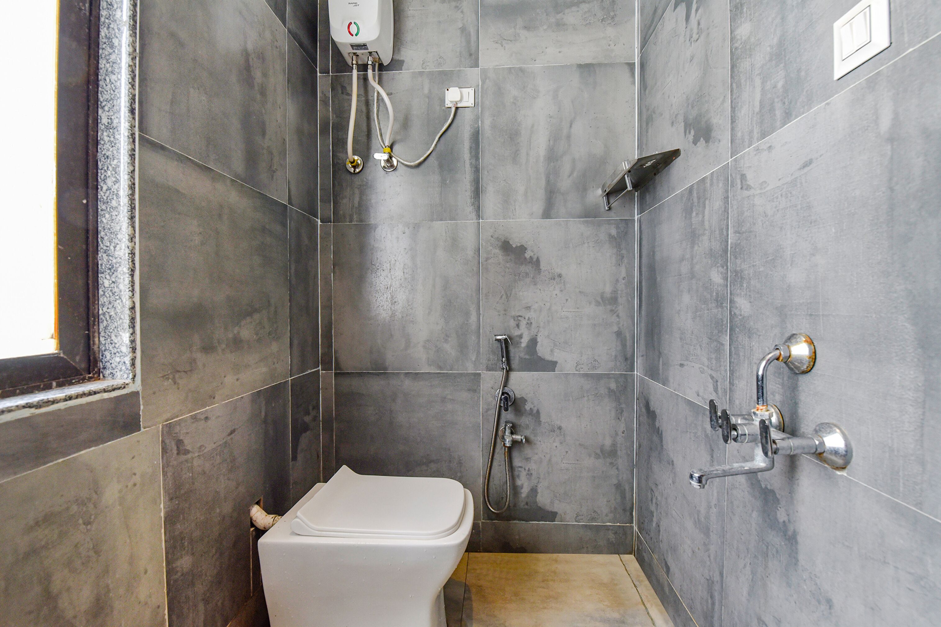 A small, modern bathroom with a toilet, a shower, and a sink.