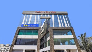 Un edificio moderno con un letrero que indica 'Infinity Biz Hub' y 'Fab Hotels'.