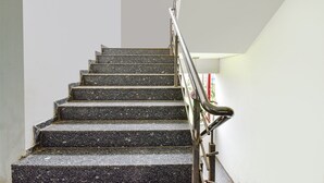 Una escalera con barandilla de metal que sube a un piso superior.