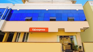 A building with a blue facade, a 'fabexpress' sign, and a 'UV RESIDENCY' entrance. - Fabexpress Uv Residency (Coimbatore)