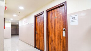 Un couloir avec deux portes en bois, un panneau indiquant « Il est interdit de fumer » et un autre panneau indiquant « Chambre non-fumeur ».