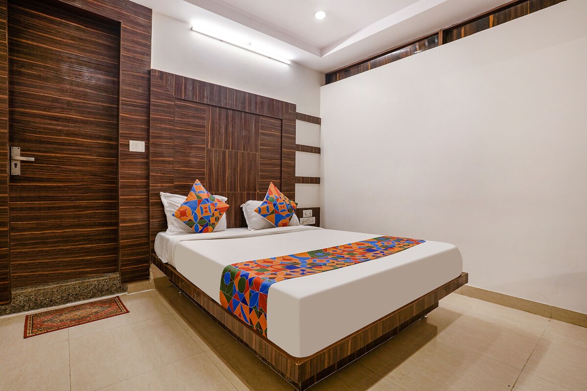 Un dormitorio moderno con una cama grande, paneles de madera en las paredes y una colcha estampada.