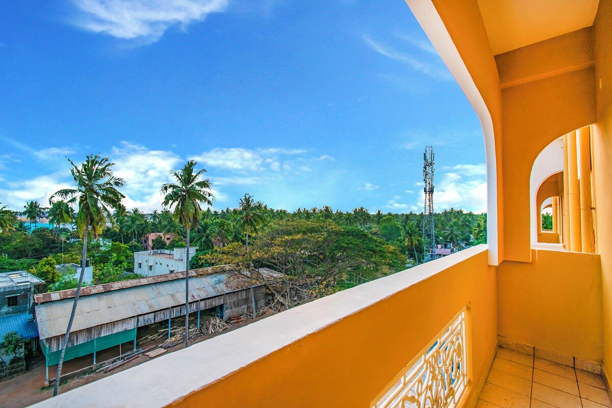 A balcony with a view of a residential area, including houses and palm trees.