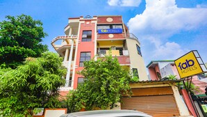 A multi-story building with a 'fab hotels' sign, balconies, and a garage door. - Fabexpress Jai Manglam Service Apartment (Nagpur)