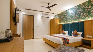 Quarto moderno com cama, mesas de cabeceira, ventilador de teto e papel de parede floral.