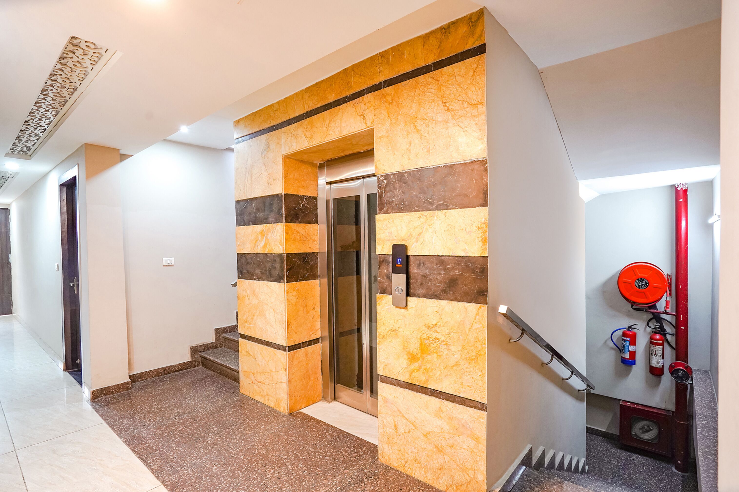 An elevator with a modern design, a fire extinguisher, and a handrail on the right side.