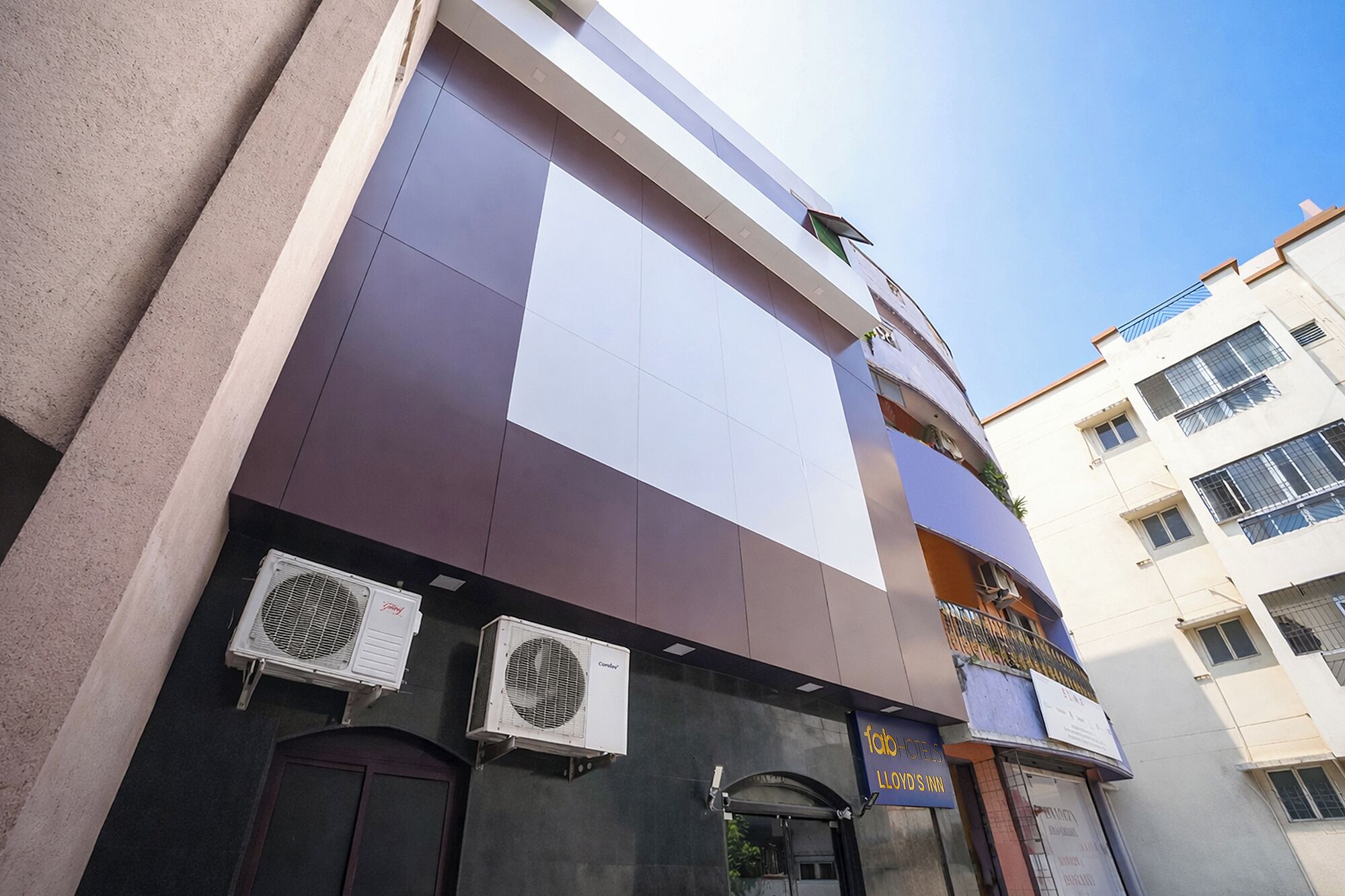 A building with a large sign for 'Lloyd's Inn' and two air conditioning units mounted on the exterior wall.