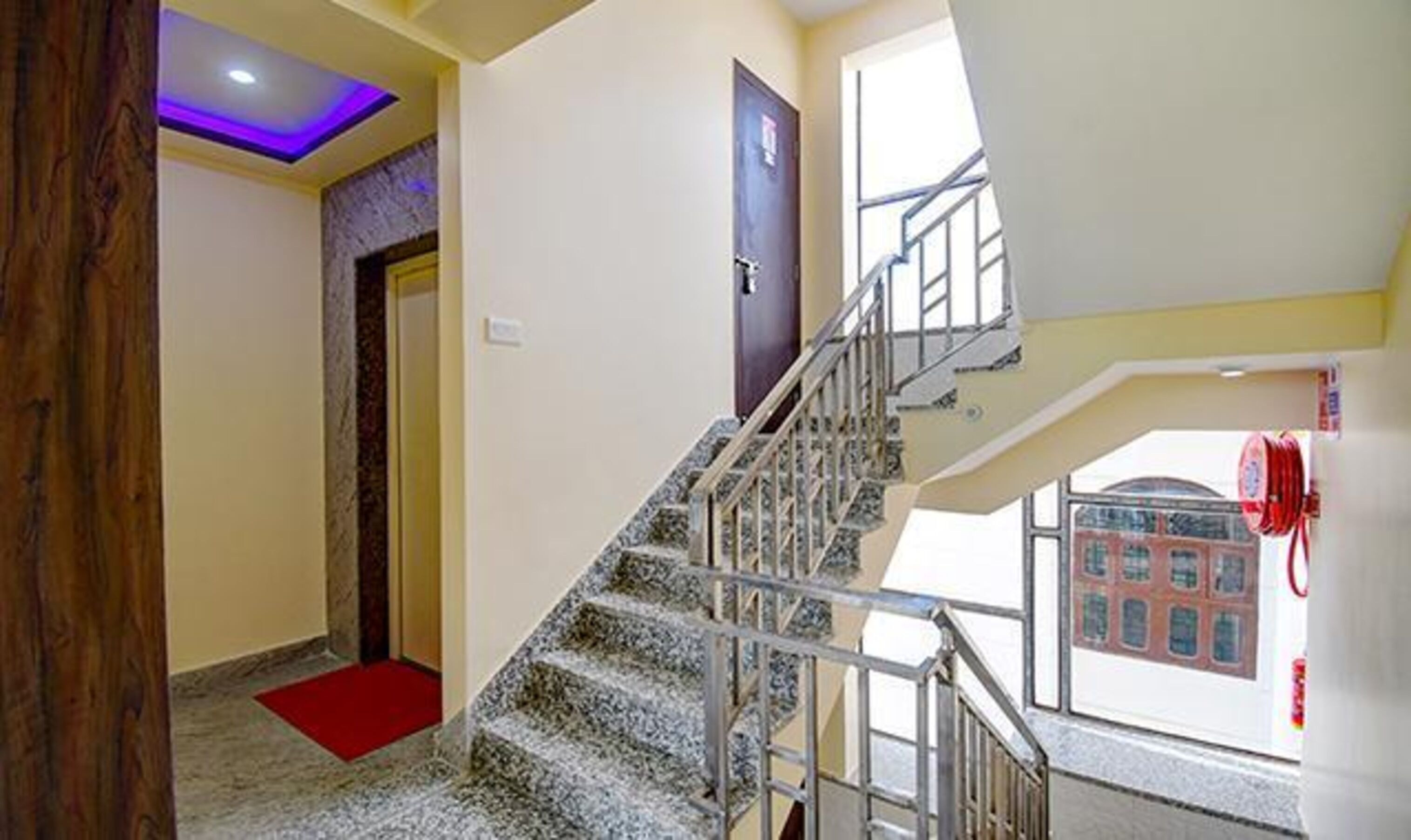 Un escalier avec une rampe métallique menant à l’étage supérieur.