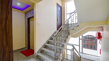 Una escalera con barandilla de metal que sube a un piso superior.