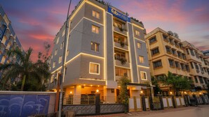 A multi-story hotel with a modern design, featuring balconies and a prominent 'fabhotels' sign.