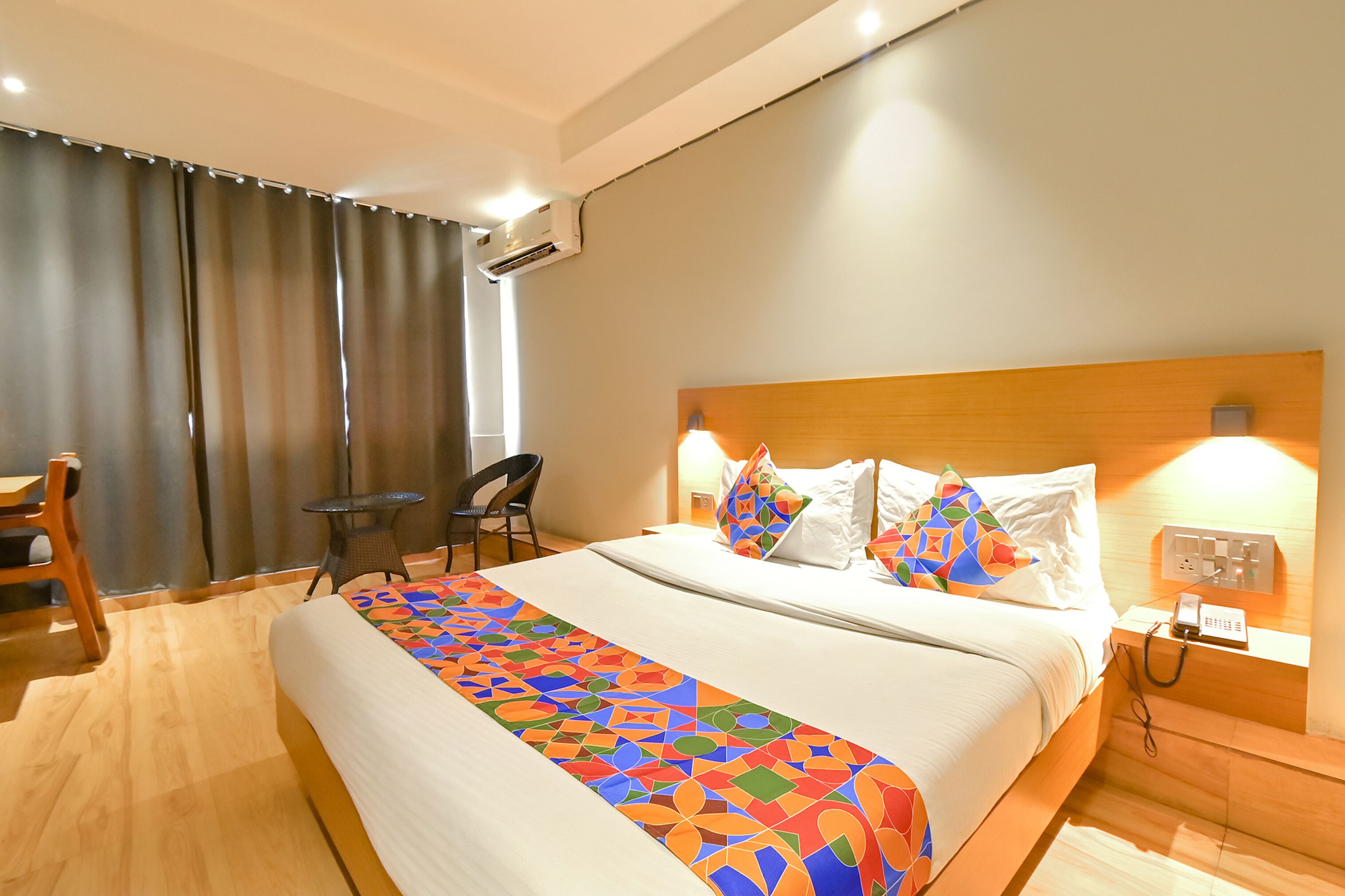 Une chambre d’hôtel avec un grand lit, un bureau, une chaise et une petite table.