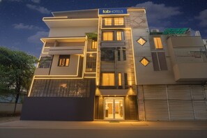 A modern hotel facade with a prominent 'fabHOTELS' sign, large windows, and a gated entrance. - FabHotel Trish The Gera (New Delhi)