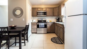 A compact kitchen with a dining area, featuring a microwave, stove, and refrigerator. - Cozy Mountain Getaway: Perfect for Families, Groups and Pets (Tannersville)